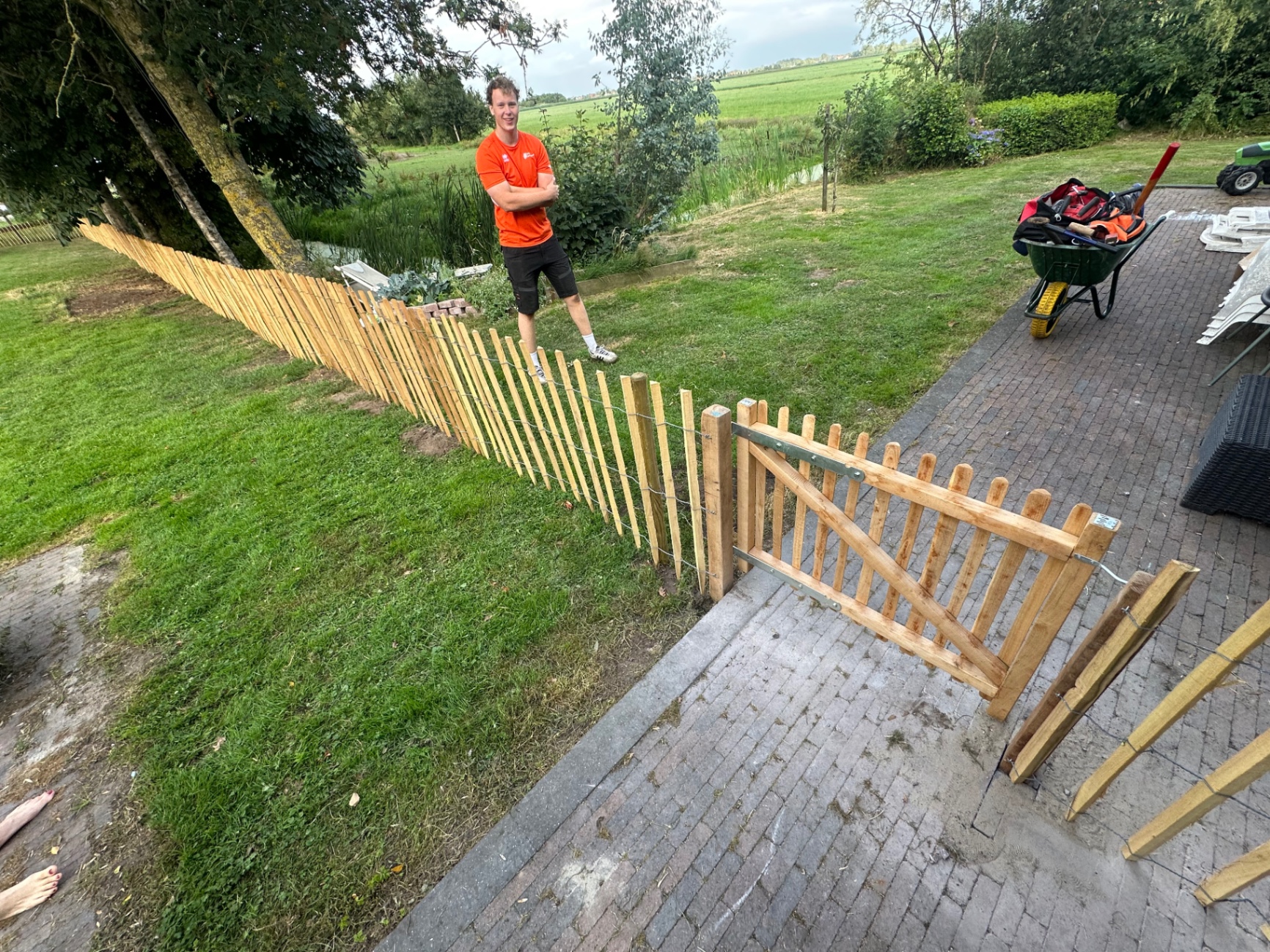 Nieuw geplaatst schapenhek met poort langs een gazon